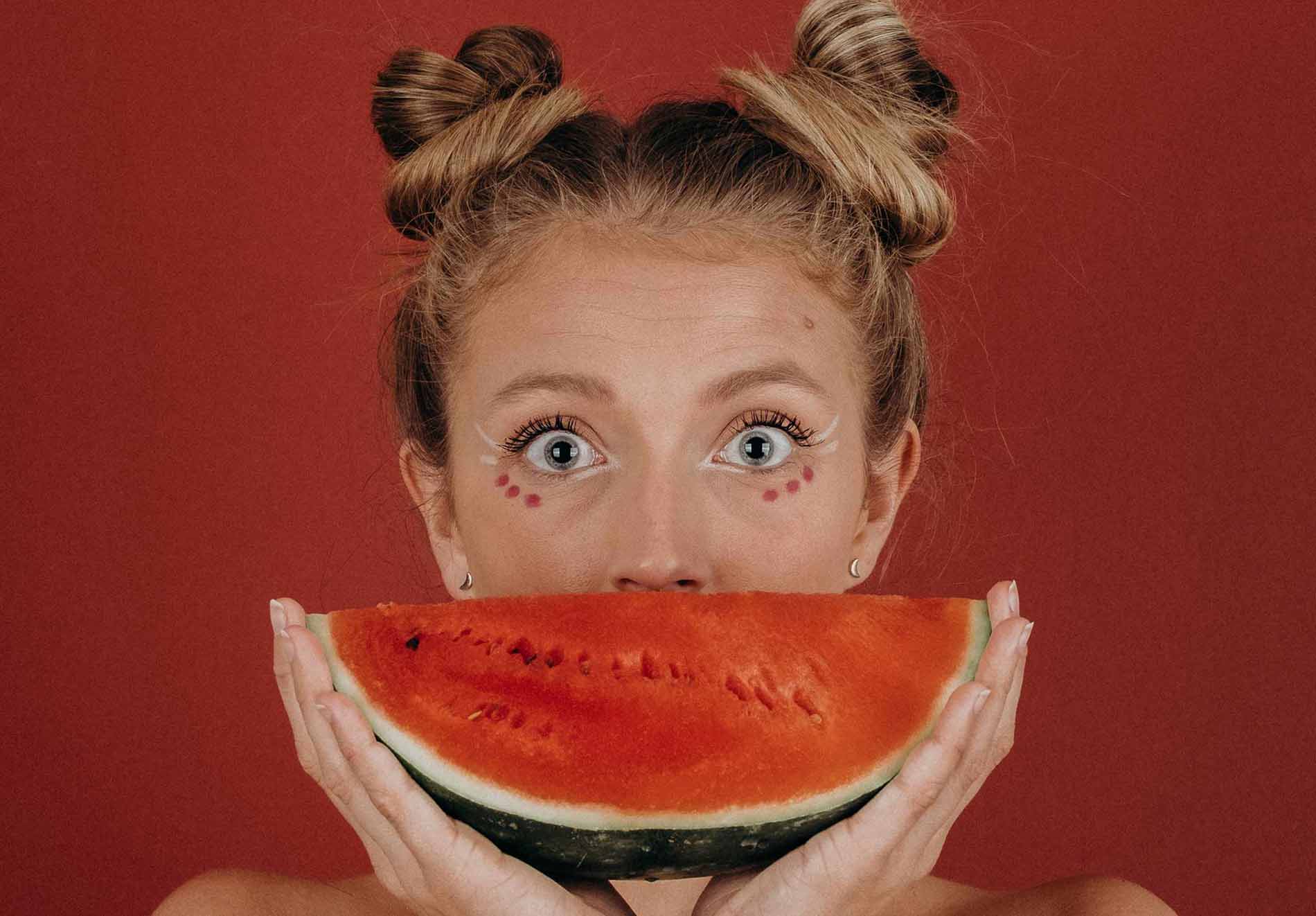 Woman Holding Watermelon Slice in Front of Her Face